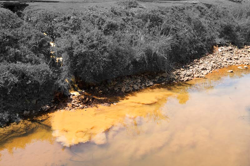 Untreated acid mine drainage being released into Tipong river in Makum Coalfield in Tinsukhia district, Assam, which pollutes the river water and affects the dependent rural communities as well as the flora and fauna around